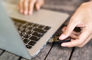 hand putting usb in laptop